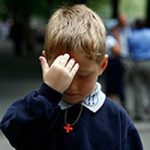 Un enfant fait son signe de croix