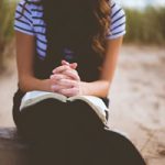 Jeune femme qui prie avec bible par Ben White (unsplash.com)