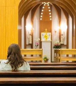 Femme en prière dans une église de Mateus Campos Felipe (unsplash.com)