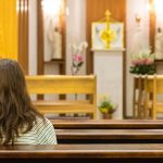 Femme en prière dans une église de Mateus Campos Felipe (unsplash.com)