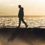 Homme qui marche Il Vano près d'un rivage par (unsplash.com)